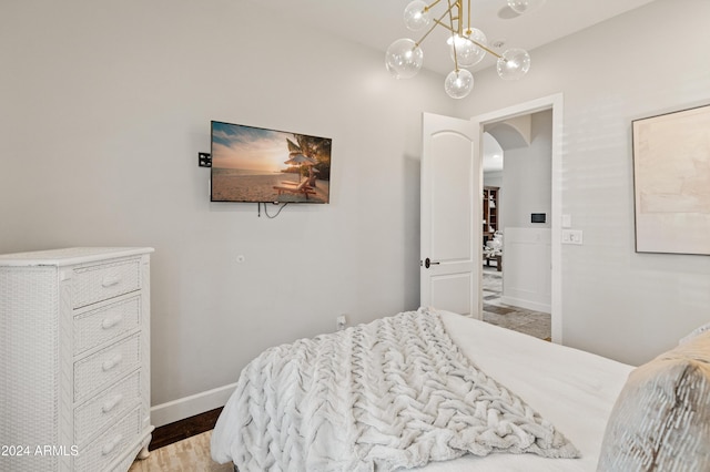 1409 E Dove Pl, Casa Grande, AZ 85122 - bedroom with arched walkways, baseboards, a chandelier, and wood finished floors