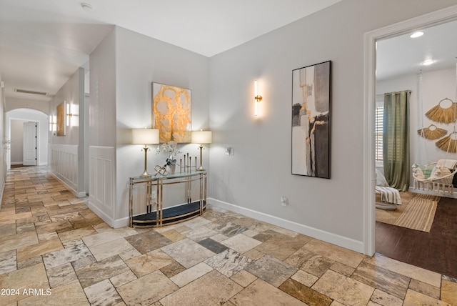 1409 E Dove Pl, Casa Grande, AZ 85122 - corridor featuring arched walkways, stone tile flooring, and baseboards