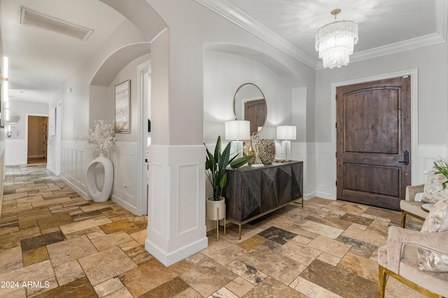 1409 E Dove Pl, Casa Grande, AZ 85122 - foyer with stone tile flooring, wainscoting, a decorative wall, ornamental molding, and a chandelier
