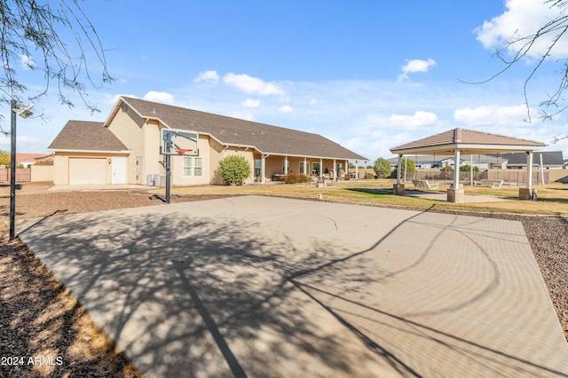 1409 E Dove Pl, Casa Grande, AZ 85122 - view of front of home with a gazebo, basketball hoop, stucco siding, an attached garage, and driveway