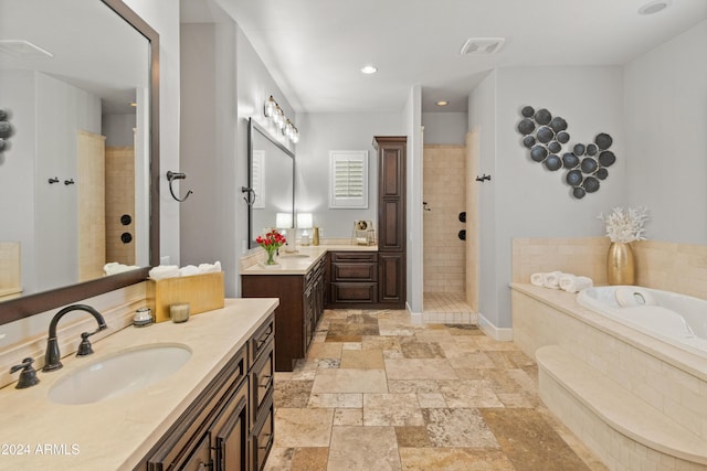 1409 E Dove Pl, Casa Grande, AZ 85122 - bathroom with a bath, two vanities, tiled shower, stone tile flooring, and recessed lighting