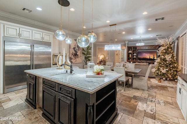 1409 E Dove Pl, Casa Grande, AZ 85122 - kitchen featuring built in fridge, a sink, crown molding, stone tile flooring, and white cabinets
