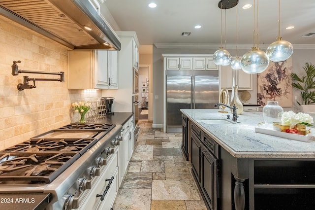 1409 E Dove Pl, Casa Grande, AZ 85122 - kitchen with wall chimney range hood, stone tile flooring, built in appliances, a sink, and ornamental molding