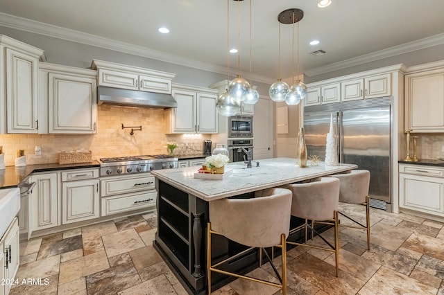 1409 E Dove Pl, Casa Grande, AZ 85122 - kitchen featuring built in appliances, under cabinet range hood, cream cabinets, backsplash, and crown molding
