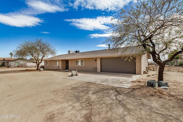 ranch-style home with stucco siding, driveway, and a garage