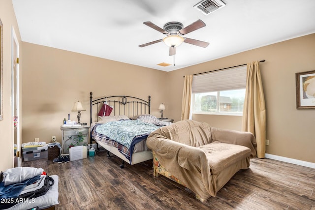 bedroom with ceiling fan, visible vents, baseboards, and wood finished floors