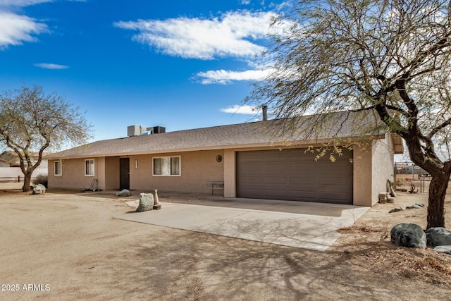 single story home with stucco siding, driveway, and a garage