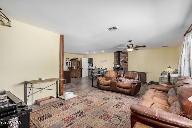 living room featuring wood finished floors, a ceiling fan, and visible vents