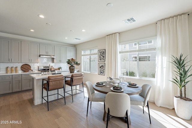 dining room with recessed lighting, visible vents, and light wood-type flooring