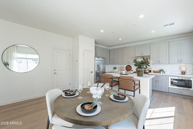 dining area with recessed lighting, baseboards, visible vents, and light wood finished floors