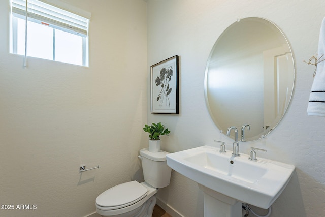 half bath with toilet and a sink