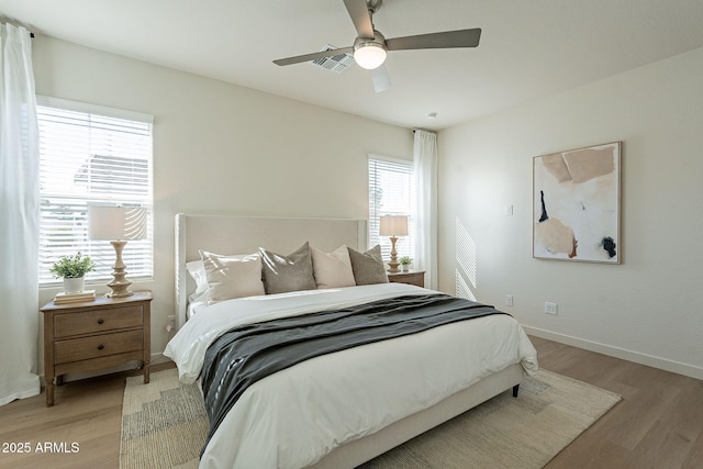 bedroom with light wood-type flooring, baseboards, visible vents, and a ceiling fan