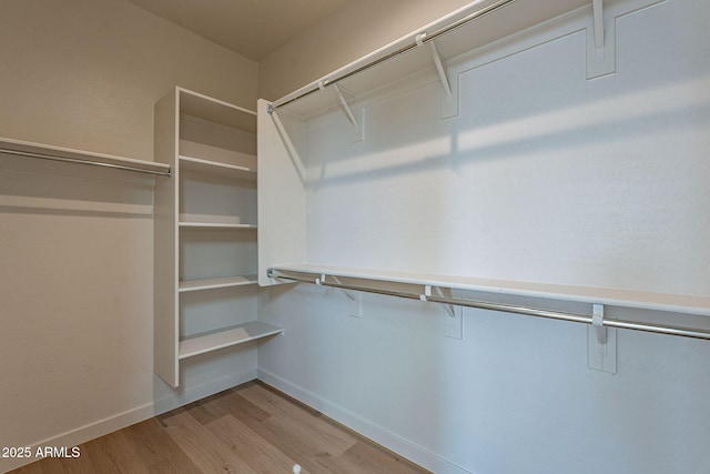 walk in closet with wood finished floors