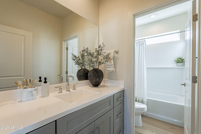 bathroom with shower / bathtub combination with curtain, toilet, vanity, and wood finished floors