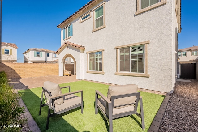 back of house with stucco siding, a patio, a fenced backyard, and a tile roof