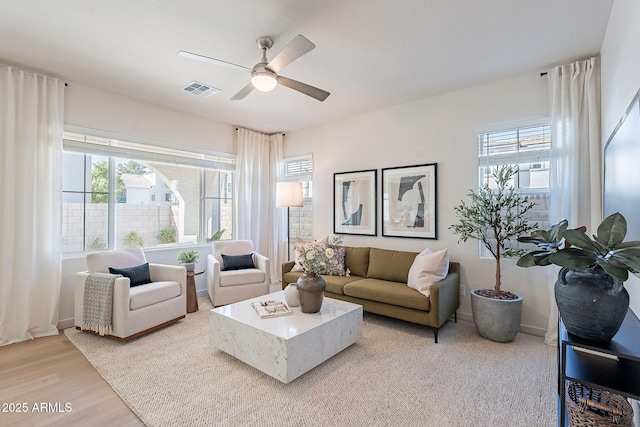 living room with visible vents, a healthy amount of sunlight, a ceiling fan, and wood finished floors