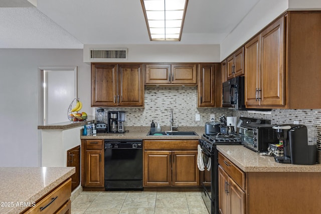 kitchen with black appliances, light tile patterned floors, decorative backsplash, and sink