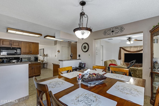 dining room featuring a textured ceiling and ceiling fan