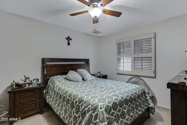 carpeted bedroom with ceiling fan and a textured ceiling