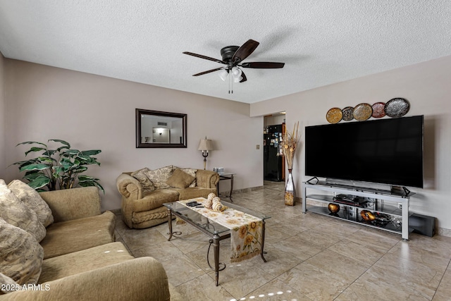 living room featuring ceiling fan and a textured ceiling