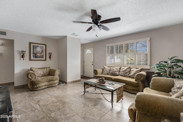 living room featuring ceiling fan and a textured ceiling