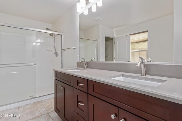 full bath with double vanity, a stall shower, a sink, and tile patterned floors