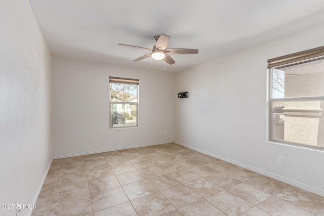 unfurnished room with ceiling fan and baseboards