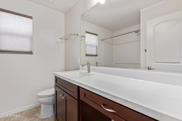 bathroom featuring baseboards, vanity, toilet, and tile patterned floors