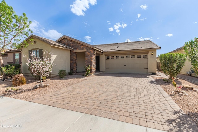 view of front of house with a garage, stone siding, decorative driveway, and stucco siding