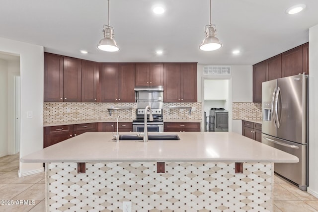 kitchen featuring appliances with stainless steel finishes, light countertops, light tile patterned flooring, and a kitchen bar