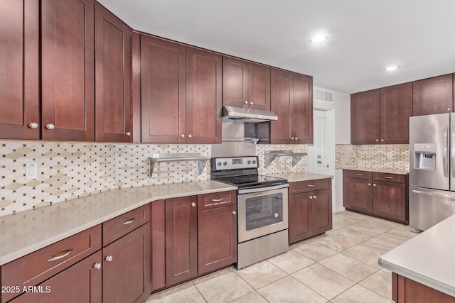 kitchen featuring appliances with stainless steel finishes, light countertops, under cabinet range hood, and light tile patterned floors