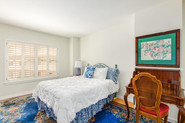 bedroom featuring wood finished floors and baseboards