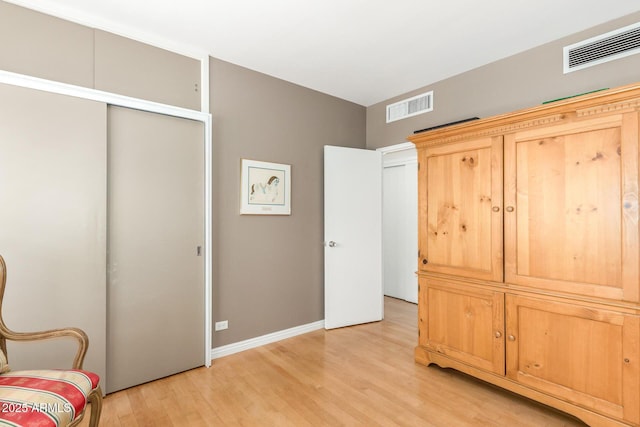 sitting room with light wood-type flooring, baseboards, and visible vents