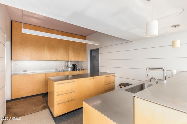 kitchen featuring light countertops, a sink, and decorative light fixtures