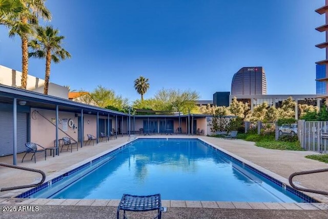 pool with a patio and fence