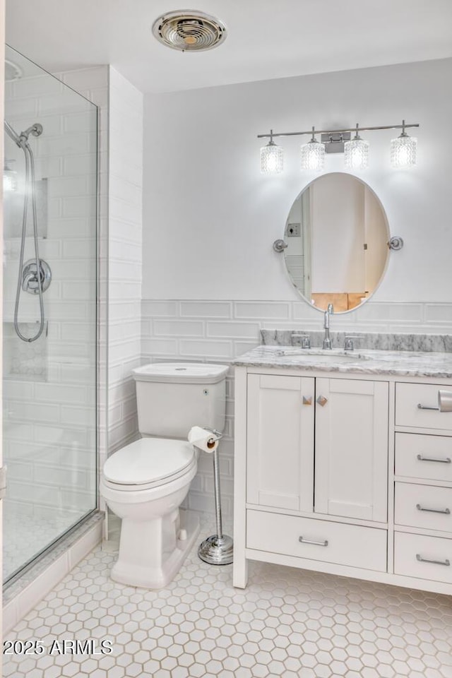2201 N Central Ave Unit 3D, Phoenix, AZ 85004 - full bath featuring a shower stall, toilet, vanity, tile patterned flooring, and wainscoting