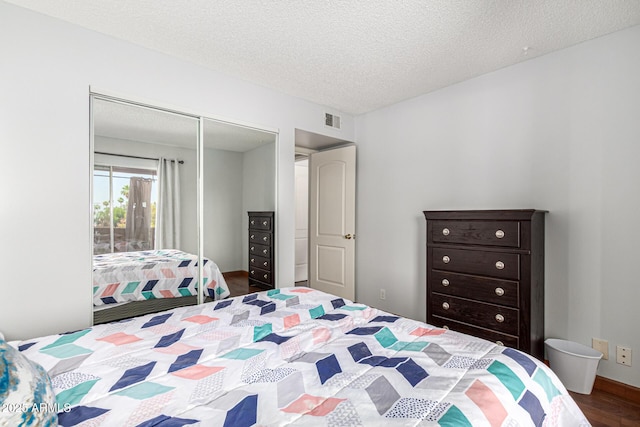 540 N May Unit 3117, Mesa, AZ 85201 - bedroom featuring a closet, dark wood-style flooring, and a textured ceiling