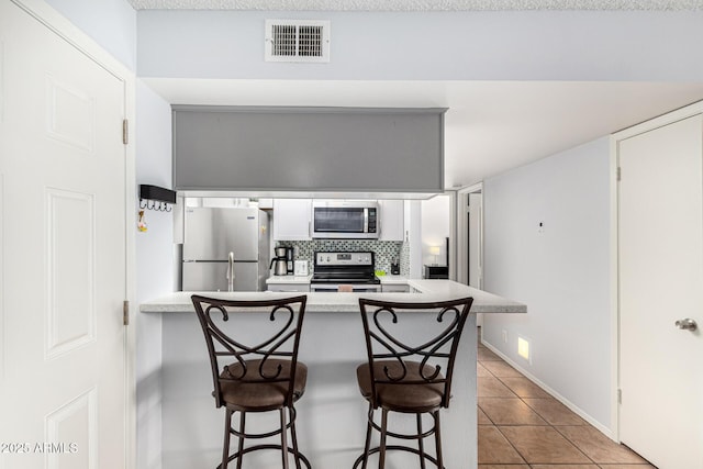 540 N May Unit 3117, Mesa, AZ 85201 - kitchen with appliances with stainless steel finishes, a peninsula, tile patterned flooring, and a breakfast bar area