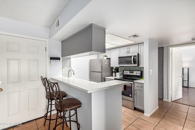 540 N May Unit 3117, Mesa, AZ 85201 - kitchen featuring stainless steel appliances, light tile patterned floors, gray cabinetry, and a breakfast bar