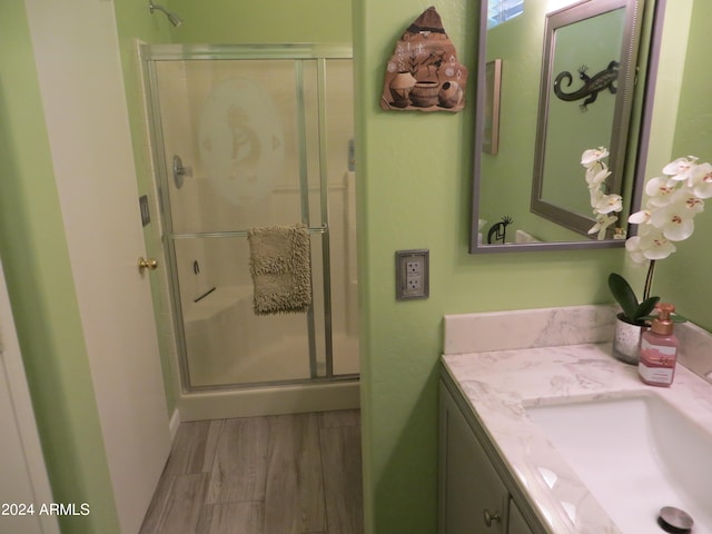 bathroom with wood-type flooring, vanity, and walk in shower