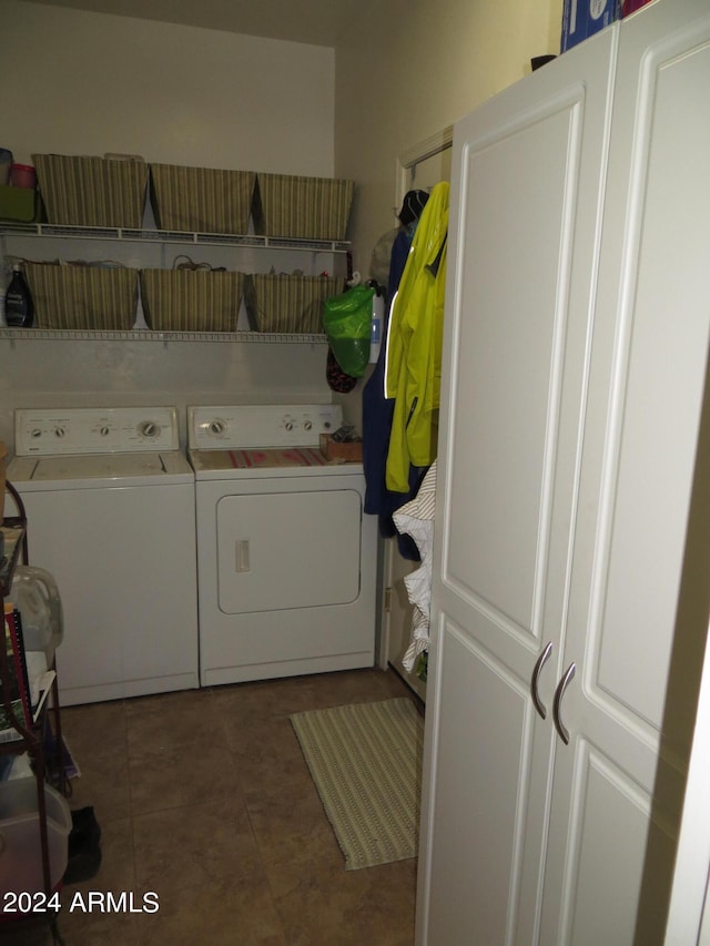 clothes washing area with dark tile patterned floors and washing machine and clothes dryer