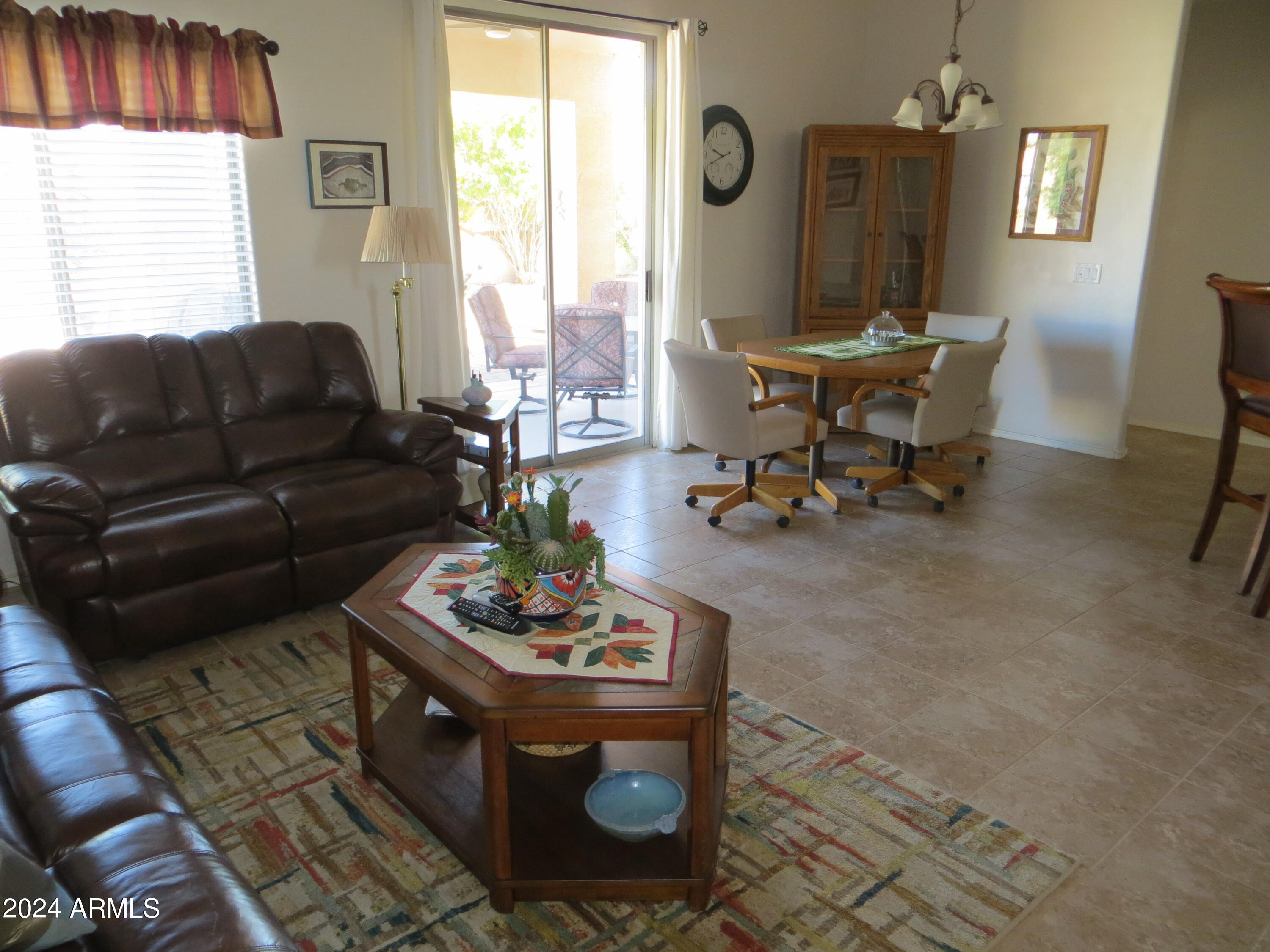 living room with a notable chandelier, light tile patterned floors, and a wealth of natural light