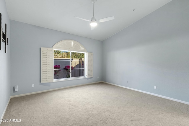 carpeted empty room with lofted ceiling, ceiling fan, and baseboards