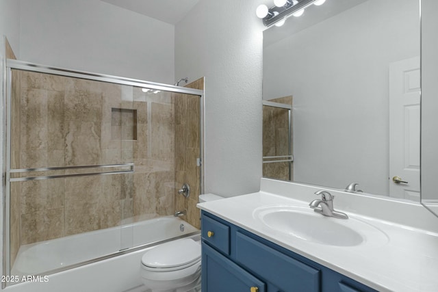 bathroom featuring combined bath / shower with glass door, vanity, and toilet