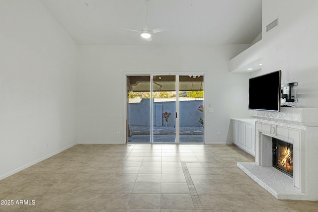 unfurnished living room with baseboards, a premium fireplace, visible vents, and a ceiling fan