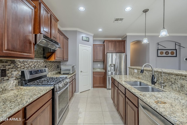 kitchen featuring sink, light stone counters, decorative light fixtures, light tile patterned flooring, and appliances with stainless steel finishes