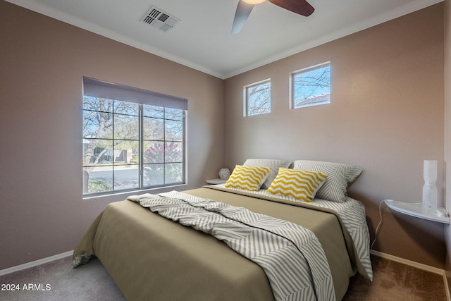 carpeted bedroom with ceiling fan and ornamental molding