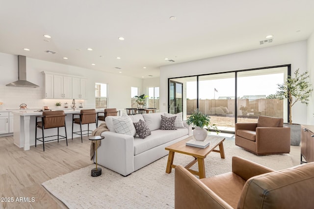 living room featuring a wealth of natural light and light hardwood / wood-style flooring