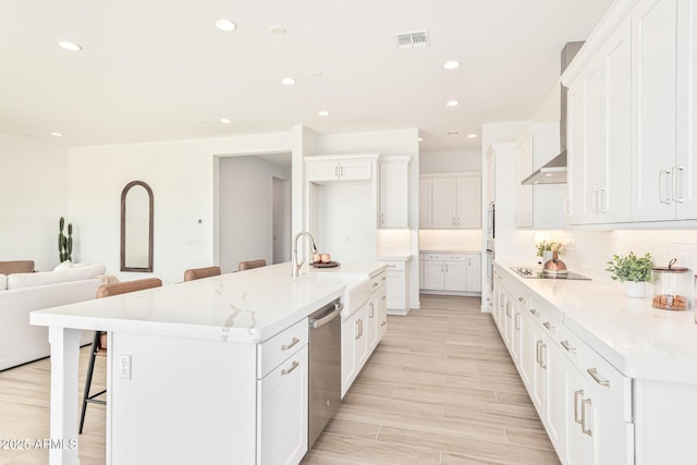 kitchen with white cabinetry, dishwasher, a breakfast bar area, backsplash, and a large island