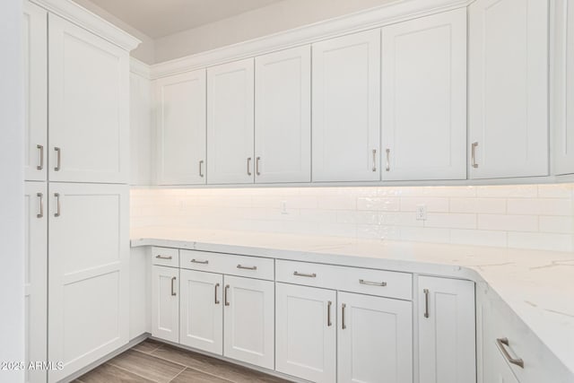 kitchen featuring white cabinetry, tasteful backsplash, and light stone countertops